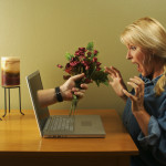 Online dating concept. Hand & Wine Glass Through Laptop Screen